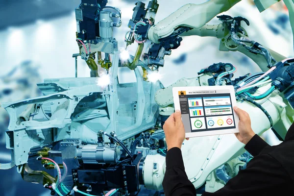 iot industry 4.0 concept,industrial engineer using software (augmented, virtual reality) in tablet to monitoring machine in real time.Smart factory use Automation robot arm in automotive manufacturing