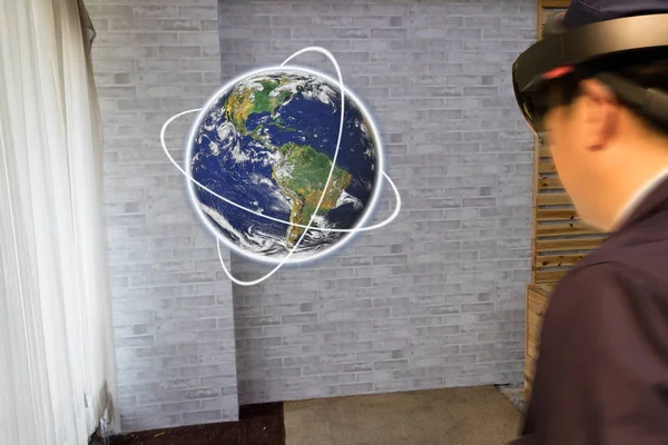 smart education industrial technology concept, man (blurred) using smart glasses study about the world/globe in 3d by using augmented mixed virtual reality Elements of this image furnished by NASA