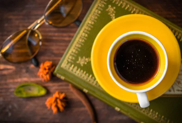 top view,coffee and book with autumn leaves on wood background - seasonal relax concept