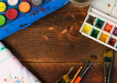 Boyalar ve fırçalar ahşap arka plan üzerinde