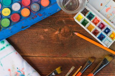 Boyalar ve fırçalar ahşap arka plan üzerinde