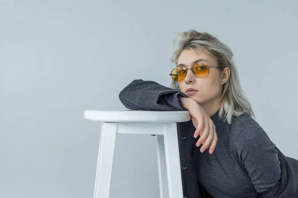 gri arka plan, beyaz bir sandalye ile poz şık kadın dansçı
