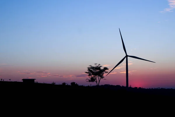 Yalnız bir rüzgar türbini karşı dramatik bir günbatımı gökyüzü kontrast. 