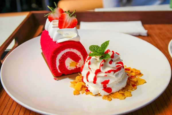 Çilek kırmızı kadife kek üzerine rulo ile şamar krem ve beyaz çanak üzerinde Mısır gevreği.