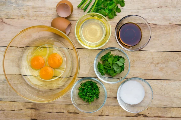 Çiğ yumurta ve malzemeler ahşap arka plan üzerinde. Vejetaryen yiyecekler, sağlık veya pişirme kavramı.