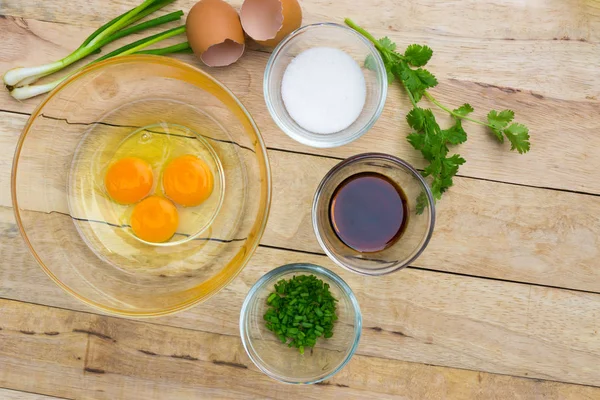 Çiğ yumurta ve malzemeler ahşap arka plan üzerinde. Vejetaryen yiyecekler, sağlık veya pişirme kavramı.