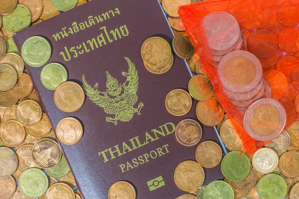Pasaporte tailandés en una pila de monedas . — Foto de Stock