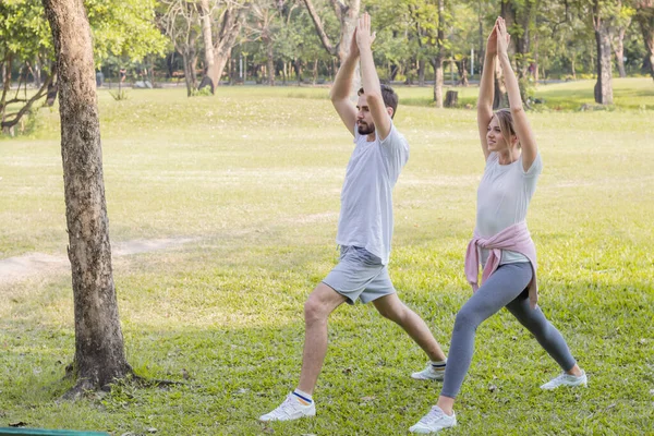 Las parejas están haciendo ejercicio en el parque . — Foto de Stock