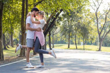 Couples standing kiss and hugging in the park.
