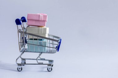 Beyaz arkaplanda hediye kutusu olan alışveriş arabası..