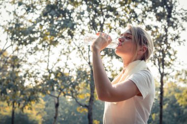 Güzel kızlar yorucu egzersizden sonra su içiyorlar..