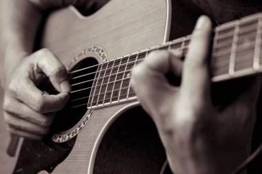 Müzisyenler akustik gitar çalıyorlar.