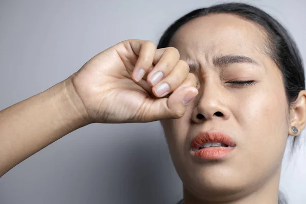 Woman suffering from strong eye pain.