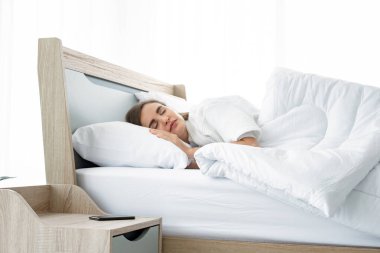 Genç ve güzel, evdeki yatakta uyuyor..