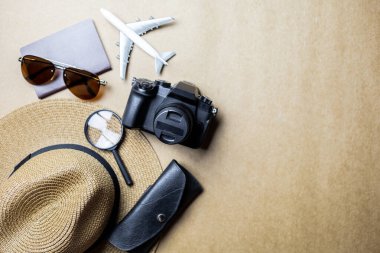 Kahverengi arka planda gezginler için kullanılan aksesuarların üst görünümü. Seyahat aksesuarları ve kopyalama alanı. Üst görünüm seyahat aksesuarları kavramı.