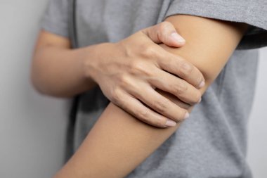 Dirseği ağrıyan kadınlar. Dirsekte şiddetli ağrı. Genç bayan dirseğine tutun..