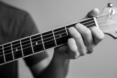 Erkekler gitar çalmayı öğreniyor. Yakın çekim müzisyenleri gitar akorlarını yakalıyor. Erkek müzisyenler akor tutar ve gitar çalar..