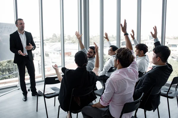 Chief listens comment to the staff in the team at the meeting. Staff expressed their opinions to the chief at the meeting room.  Employees raise their hands to ask leaders.