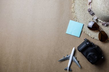 Kahverengi arka planda gezginler için kullanılan aksesuarların üst görünümü. Seyahat aksesuarları ve kopyalama alanı. Üst görünüm seyahat aksesuarları kavramı.