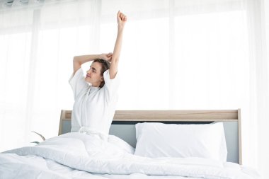 Sabah uyandıktan sonra esneme hareketleri yapan bir kadın. Güzel kadınlar ferahlatıcı bir şekilde uyanır..