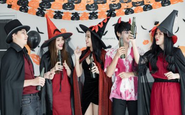 Genç Asyalı kostümlü cadı çetesi, Cadılar Bayramı partisini kutlayan büyücü dans ve içki için odada sarhoş. Gençler ve Taylandlılar Cadılar Bayramı 'nı kutluyor. Kavram partisi Cadılar Bayramı evde.