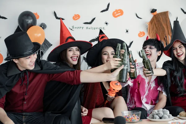 衣装の魔女で若いアジア人のギャング クリンクボトルのためのハロウィンパーティーを祝い 部屋で飲むウィザード ハロウィンを祝うグループ10代タイ コンセプトパーティー ハロウィーンアットホーム — ストック写真