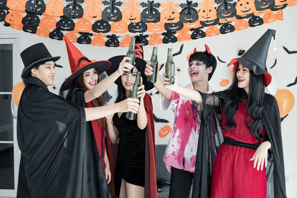 衣装の魔女で若いアジア人のギャング ダンスや飲み物のためのハロウィンパーティーを祝い 部屋で酒を飲むウィザード ハロウィンを祝うグループ10代タイ コンセプトパーティー ハロウィーンアットホーム — ストック写真
