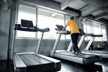Yaşlı adamlar spor salonundaki çalışan makine üzerinde egzersiz yapıyorlar. Spor salonunun son sınıfları sağlıklıdır. Spor salonunda sağlık hizmeti ve egzersiz kavramı. Spor salonunda egzersiz yapan Asyalı olgun adamlar..