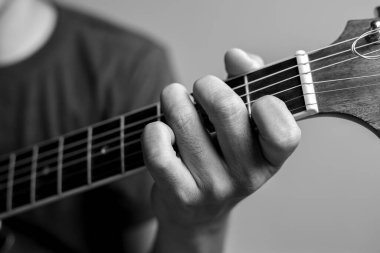 Erkekler gitar çalmayı öğreniyor. Yakın çekim müzisyenleri gitar akorlarını yakalıyor. Erkek müzisyenler akor tutar ve gitar çalar..