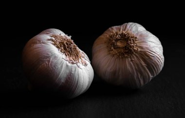 Sarımsaklı makro chiaroscuro siyah bir arka planda izole edilmiş.