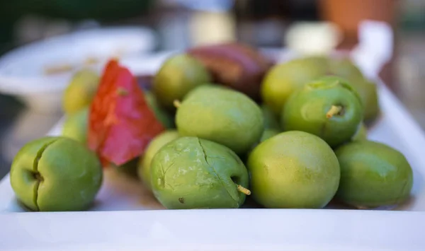 Viele marinierte Oliven mit Kräutern und Gewürzen in einem kleinen Teller auf dem Tisch der Tapas-Bar — Stockfoto
