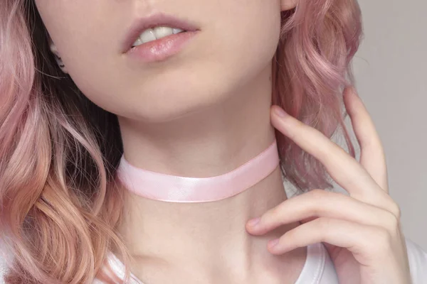 Bela jovem mulher com cabelo rosa e olhar sensual em um fundo leve tocar seu pescoço — Fotografia de Stock