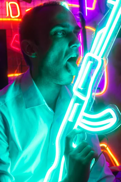 Genç adam gece portresi, neon ışıkla aydınlatılmış..