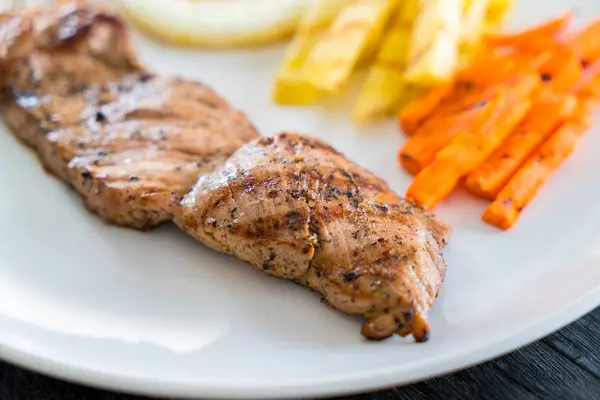 Ahşap arka plan üzerinde domuz eti biftek