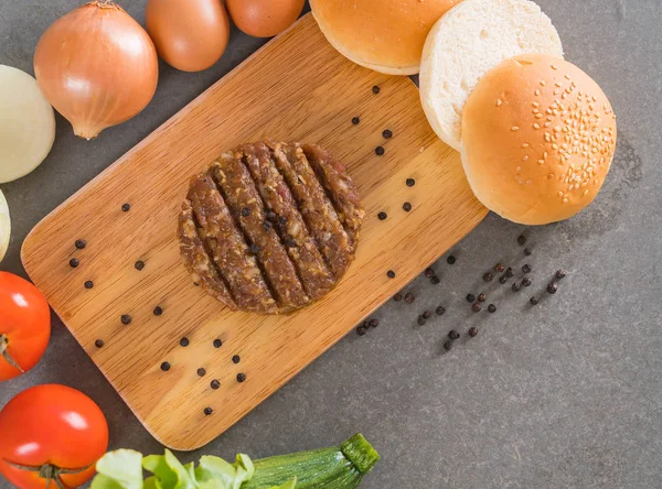 burger ingredients arranged on wooden plate