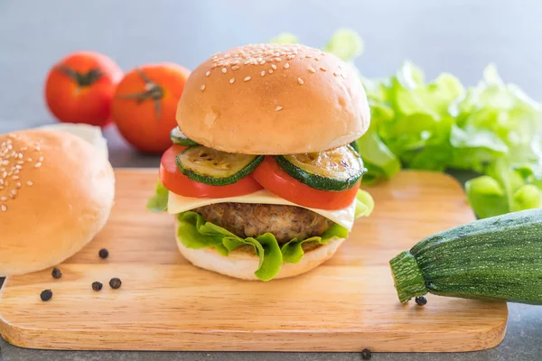 Burger na drewnianym talerzu - amerykańskie jedzenie — Zdjęcie stockowe