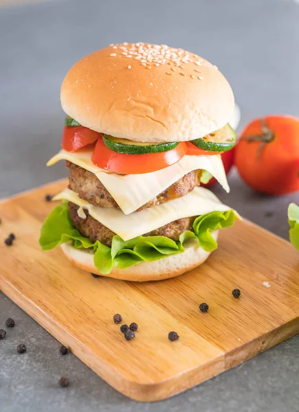 Burger na drewnianym talerzu - amerykańskie jedzenie — Zdjęcie stockowe