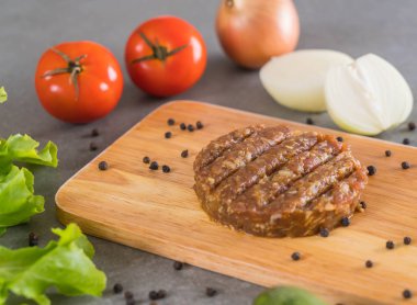 Hamburger malzemeleri ahşap tabakta dizilmiş.