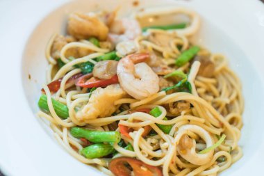 Deniz ürünleri ile tavada kızartılmış acılı spagetti