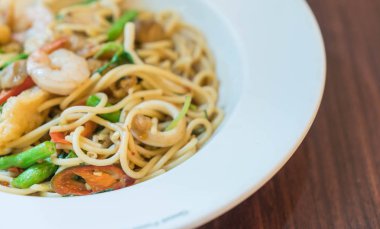 Deniz ürünleri ile tavada kızartılmış acılı spagetti