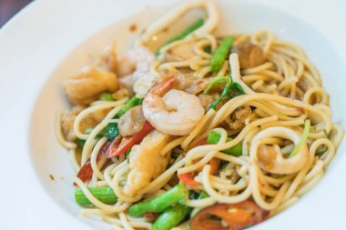 Deniz ürünleri ile tavada kızartılmış acılı spagetti