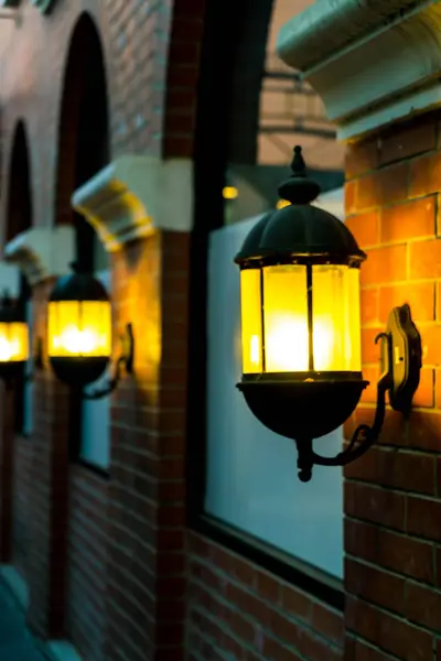 Lamp against a red brick wall at night. — Stock Photo, Image