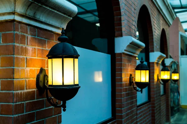 Lamp against a red brick wall at night. — Stock Photo, Image