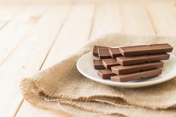Barras de chocolate sobre fondo de madera — Foto de Stock