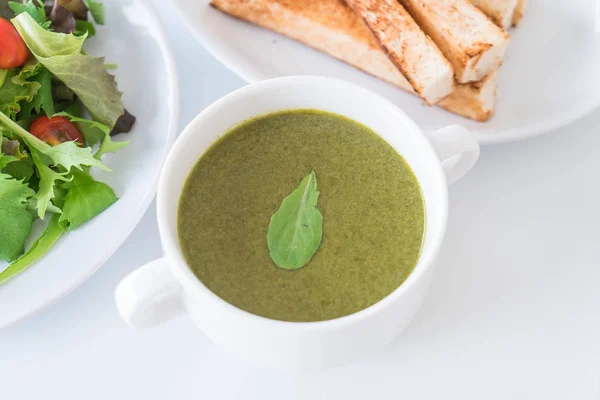 Spinach soup with spinach leaves and bread