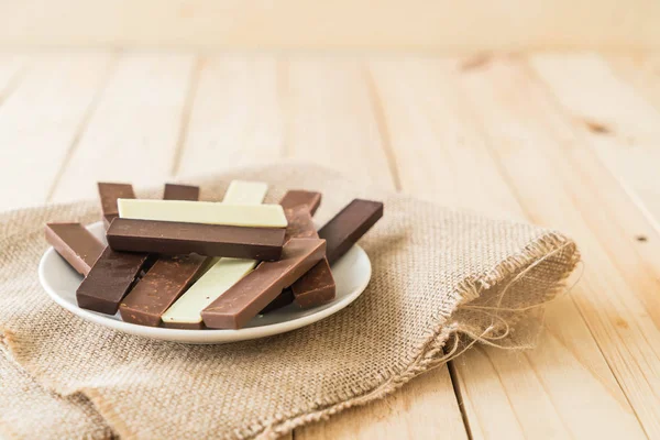 Barras de chocolate sobre fondo de madera — Foto de Stock