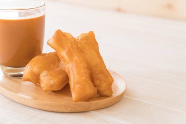 derin yağda kızartılmış hamur sopa ile süt çay