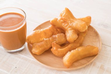 derin yağda kızartılmış hamur sopa ile süt çay