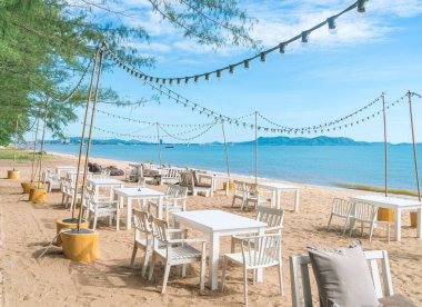 Beyaz sandalye ve sahilde tablo 