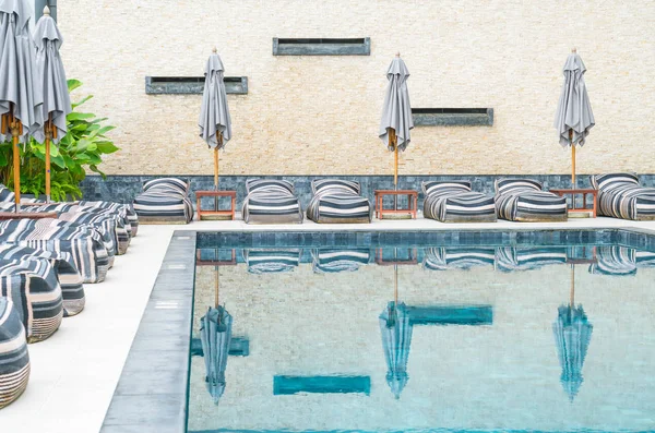 Belo guarda-chuva de luxo e cadeira em torno da piscina exterior — Fotografia de Stock